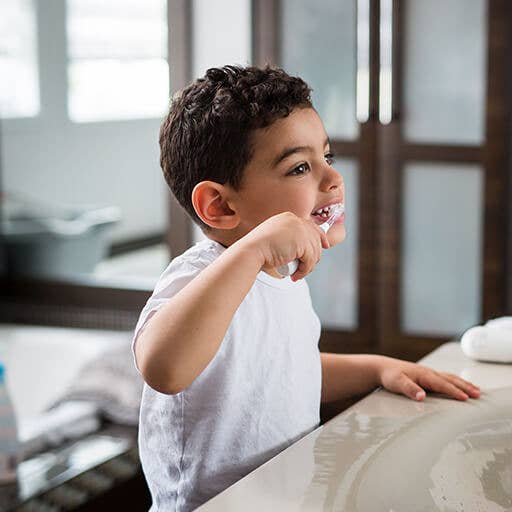 Child brushing teeth in a bathroom