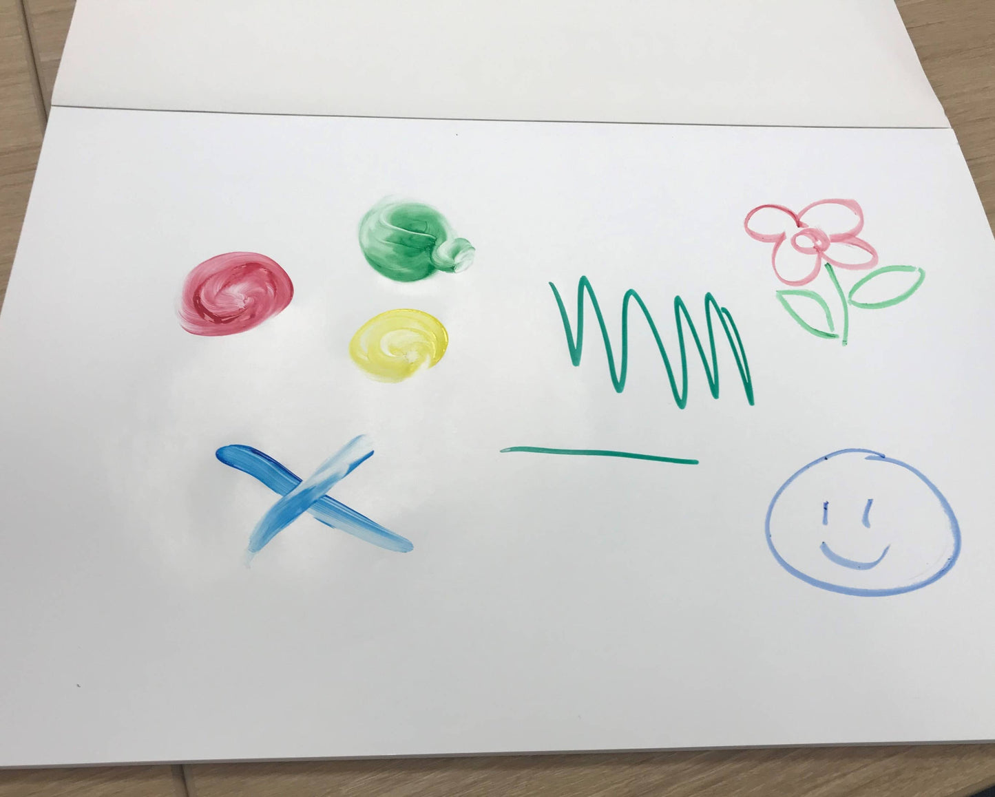 Colorful children's drawings on a white sheet of paper. 1