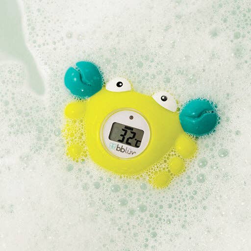 Yellow crab-shaped bath thermometer with digital display on a bubble bath background