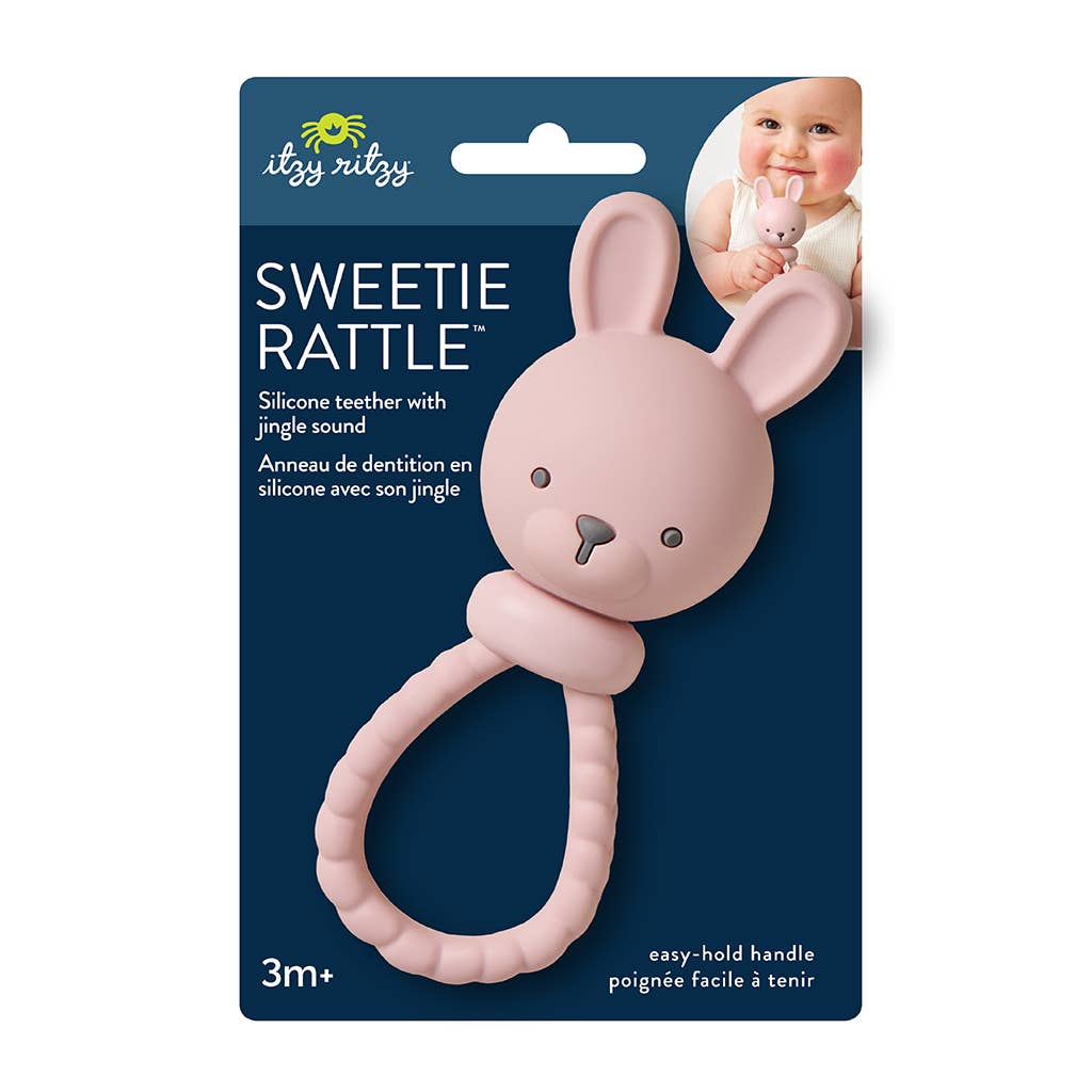 Pink bunny-shaped rattle with packaging featuring 'Itzy Ritzy' brand on a white background