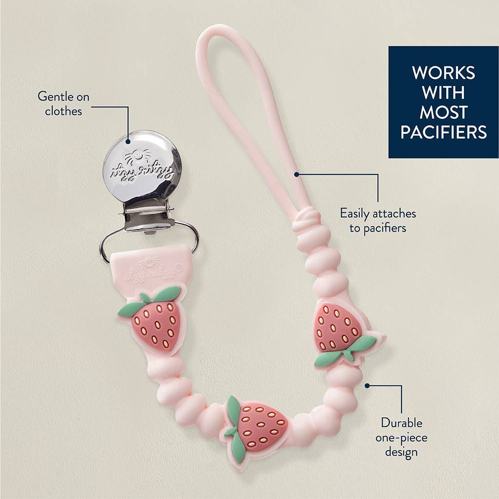 Pink strawberry-themed pacifier clip with text highlighting features on a beige background
