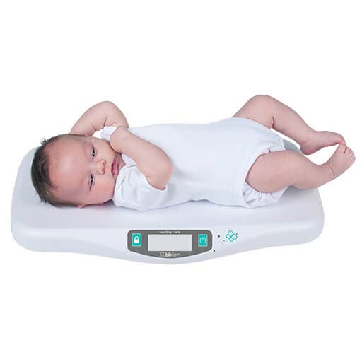Baby lying on a digital baby scale with a white background 1