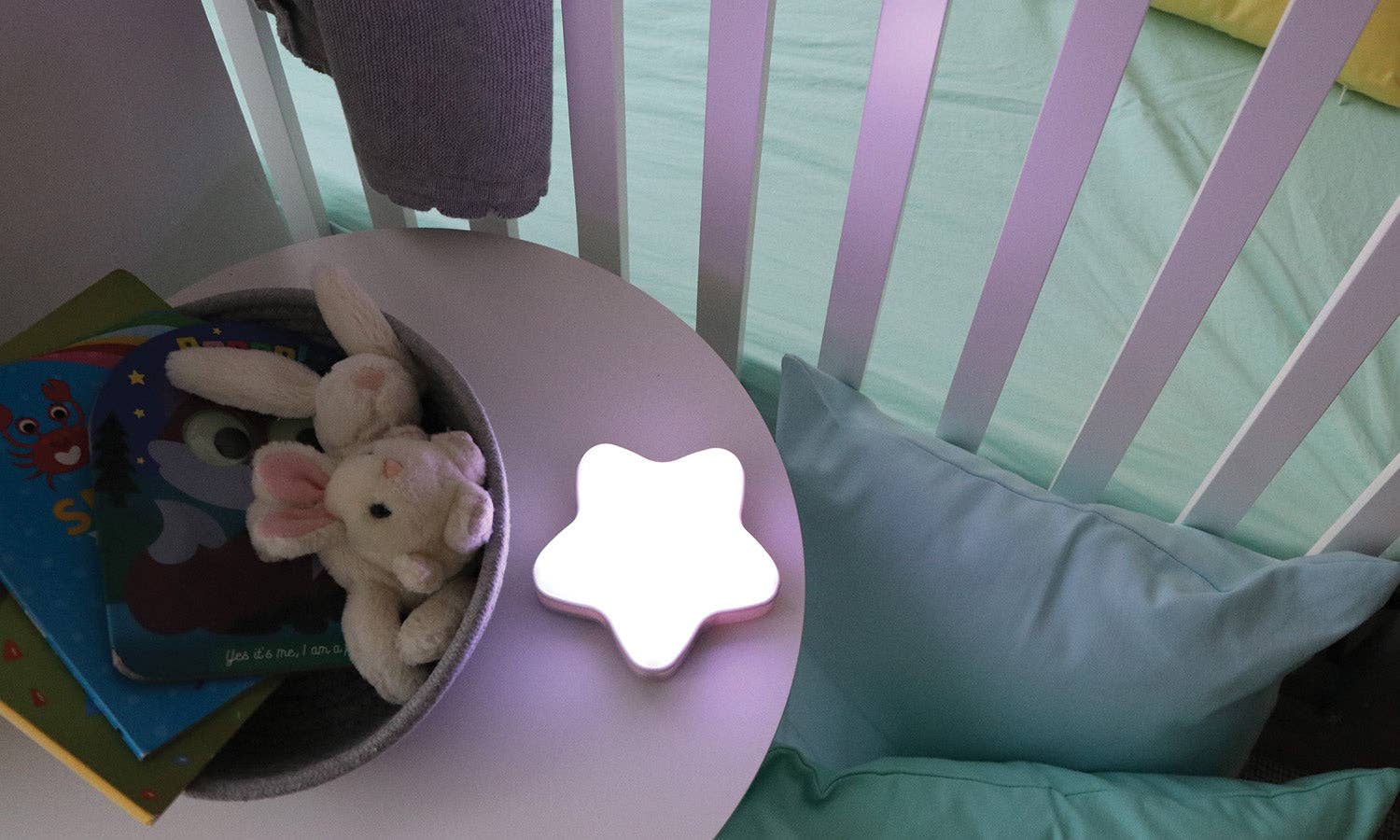 Children's room with a crib, stuffed animals, and a star-shaped night light.