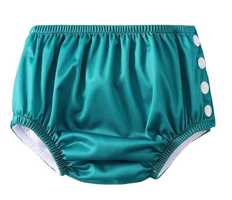 Teal baby bloomers with white buttons on a white background
